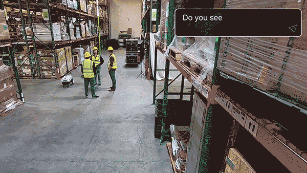 A GIF of a warehouse with people walking around.